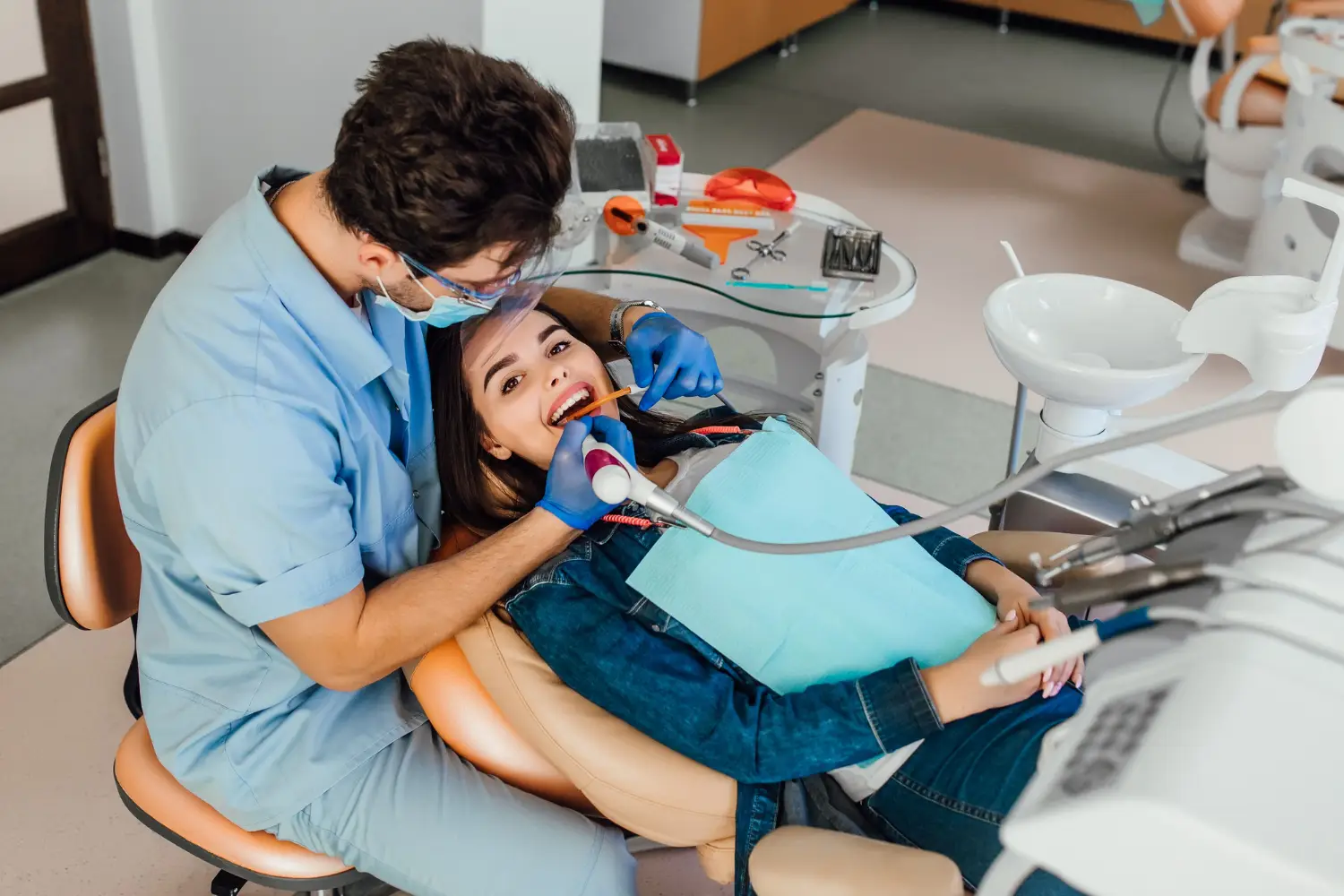 Young female patient with open mouth examining dental inspection at dentist